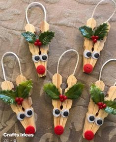 four popsicle reindeers with holly leaves and red noses are hanging on a wall