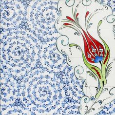 a blue and white tile with red flowers on it