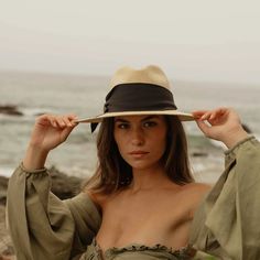 Natural straw fedora with broad brim and oversized black grosgrain band, wrapped asymmetrically around the hat and finished with a modern angular fold. 9cm brim length 9.5 cm crown height Hand Woven Panama Hat from Paja Toquilla straw Each hat is unique and reflects the natural beauty & variation of the handicraft process Small/Medium (55 cm - 57 cm), Large (58 - 59 cm) Elegant Wide Brim Toquilla Straw Fedora, Elegant Hat With Structured Crown In Natural Color, Elegant Natural Hat With Structured Crown, Chic Brimmed Fedora For Kentucky Derby, Chic Cloche Hat With Short Brim For Vacation, Chic Beige Sun Hat With Curved Brim, Chic Beige Curved Brim Sun Hat, Chic Beige Wide Brim Straw Hat, Chic Fedora Sun Hat For Kentucky Derby