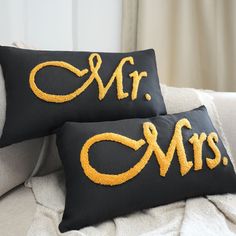 two black and gold pillows with mr and mrs embroidered on the front, one in yellow