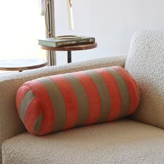 an orange striped pillow sitting on top of a couch