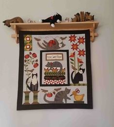 a wall hanging with cats and birds on it