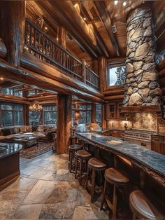 a large log cabin with stone fireplace and bar