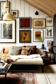 a living room with pictures on the wall and a couch in front of an area rug