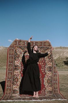 a woman standing in front of a large rug