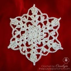 a crocheted snowflake on a red background