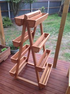 a wooden stand sitting on top of a wooden deck next to a potted plant