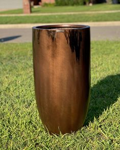 a large metal vase sitting in the grass