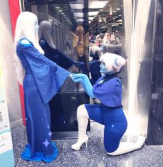 two mannequins dressed in blue and white are facing each other