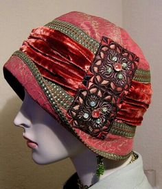 a mannequin head wearing a red hat with jewels