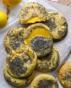 there are many cookies with yellow and black toppings on them next to some orange slices