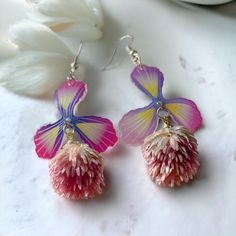 - Introducing our exquisite Floral Preserved Flower Earrings, meticulously crafted with a sturdy and high-quality feel. - The dropped flower showcases a beautiful dahlia shape, adding a unique and charming touch to the design. - Made with hypoallergenic materials, these earrings ensure comfortable wear for all, even for those with sensitive ears. - The color of the preserved flower is exceptionally beautiful, adding a vibrant and eye-catching element to your style. - The lightweight construction makes them easy to wear throughout the day without causing discomfort. - Perfect for a variety of occasions, including weddings, parties, or even as an elegant accessory for everyday wear. - Elevate your look effortlessly with these easy-to-wear, cute, and intricately detailed floral earrings. Whimsical Flower Charm Earrings For Gift, Whimsical Pink Dangle Flower Earrings, Handmade Dainty Pink Flower Earrings, Whimsical Handmade Flower Earrings For Gift, Dainty Handmade Pink Flower Earrings, Whimsical Flower Earrings With Flower Charm As A Gift, Whimsical Pink Earrings With Flower Charm, Whimsical Pink Flower Charm Earrings, Pink Whimsical Flower Earrings With Flower Charm