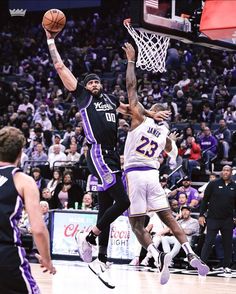 the basketball players are trying to block the ball from going into the basket in front of them