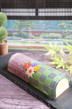 there is a vase with flowers in it sitting on the table next to some plants