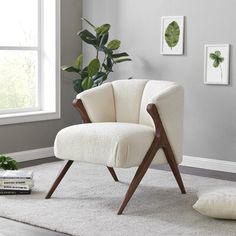 a white chair sitting on top of a rug next to a window