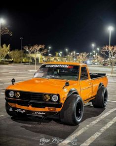 an orange truck parked in a parking lot at night