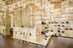 a room filled with lots of wooden shelves and shoes on top of each shelf in front of a mirror