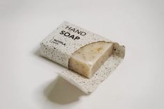 a bar of soap sitting on top of a white plate with black speckles