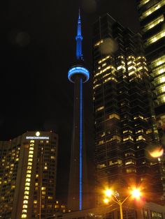 the sky tower is lit up at night