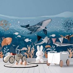 an ocean scene with toys and animals on the floor in front of blue wallpaper