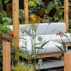 a white couch sitting in the middle of a garden