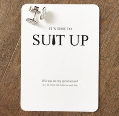 a pair of silver earrings sitting on top of a white card that says it's time to suit up