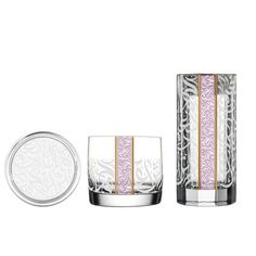 Three elegant glasses feature intricate white calligraphy patterns. Each has a vertical pink and gold stripe. The arrangement is stylish and modern.