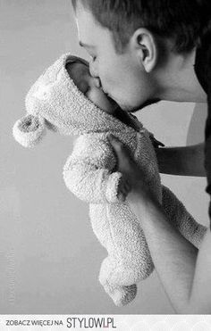 black and white photograph of a young boy holding a stuffed animal in his hands,