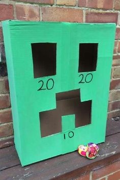 a green cardboard box with two faces cut out