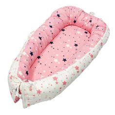 a pink and white baby bed with stars on the top, in front of a white background