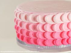 a close up of a cake with pink and white frosting on it's side