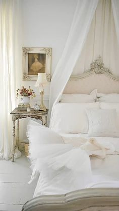 a bed with white sheets and pillows in a room