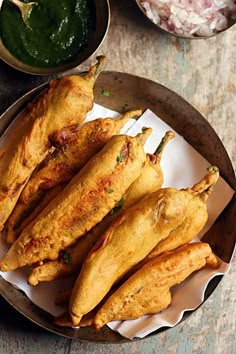 some fried food is on a plate with sauces