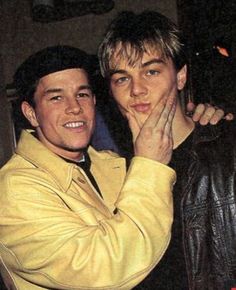 two young men are posing for the camera with their arms around each other and one is holding his hand up to his face