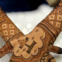 a woman's hand with henna tattoos on it, showing the letter f