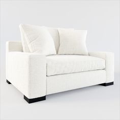 a white couch with two pillows on it's back and one arm facing the camera