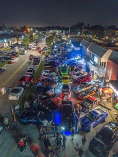 an aerial view of a busy street at night with many cars parked on both sides