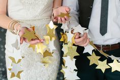 the bride and groom are holding gold stars