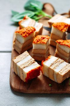 several pieces of food sitting on top of a wooden cutting board