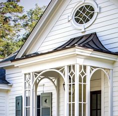 a white house with black shutters and arched windows