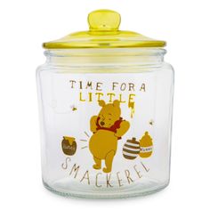 a glass jar with a winnie the pooh design on it and a yellow lid