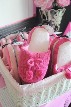 a basket filled with pink slippers on top of a table