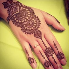 a woman's hand with henna tattoos on it