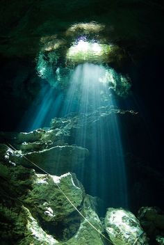 an underwater cave with sunlight shining through the water