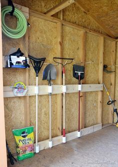 the inside of a shed with tools hanging on it