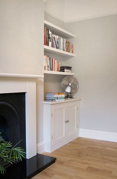 a living room with a fireplace and bookshelf