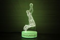 a green lamp with a soccer player on it's body in the middle of the image