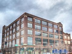 an old brick building with lots of windows on the side of it and cars parked in front