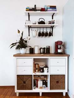 a white cabinet with baskets and coffee cups on it