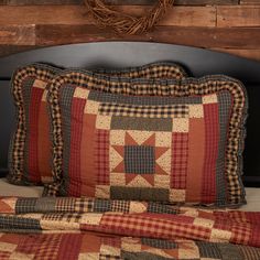 a close up of a bed with two pillows and a wreath on the headboard